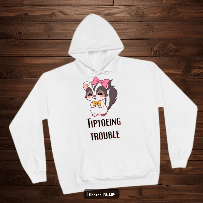 Funny skunk hoodie showing a skunk with a bright bow, tiptoeing with mischievous glee, perfect for cozy humor.